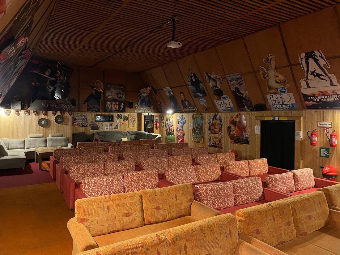 Gemuetliche Sofareihen und Filmposter im Sommerkino Blinkfeuer